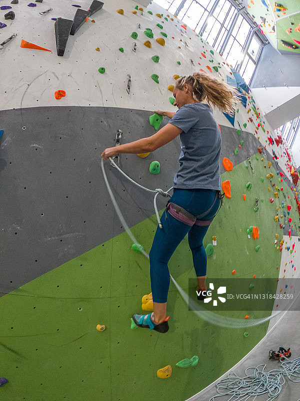 女人在抱石健身房进行室内攀岩图片素材