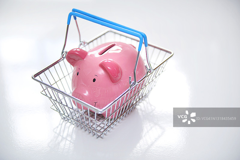 超市篮子里的粉色小猪储蓄罐图片素材