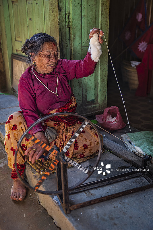 尼泊尔妇女在尼泊尔巴克塔普尔古镇纺羊毛图片素材