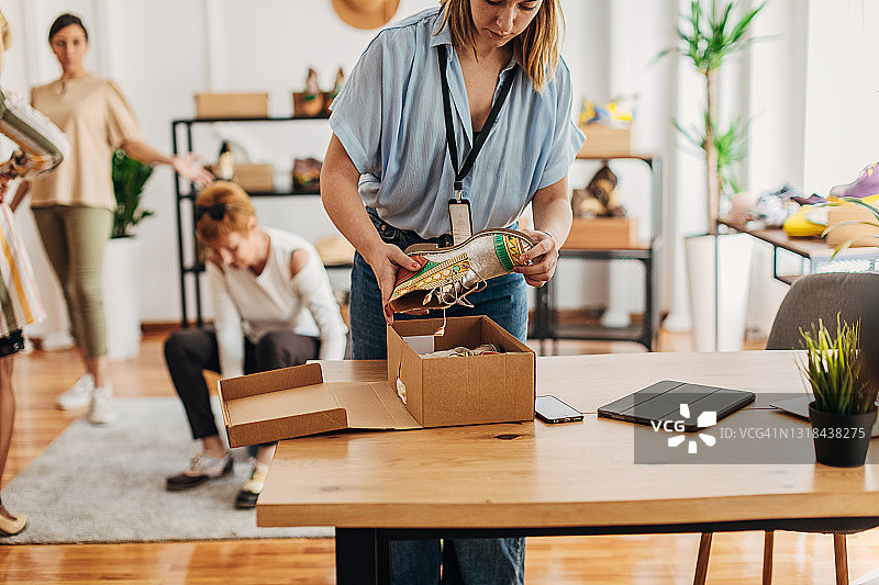 女店员正在打包一双鞋图片素材