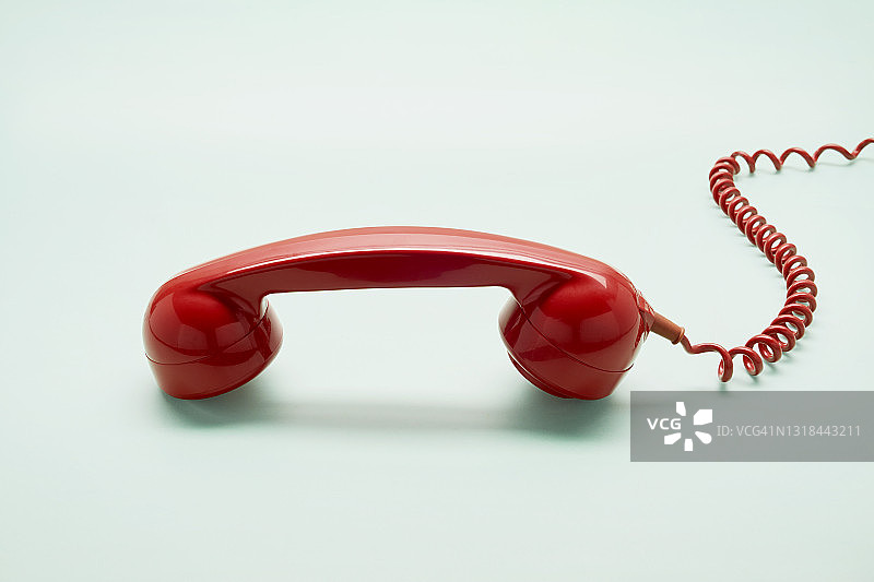 绿松石背景上的红色老式电话听筒图片素材