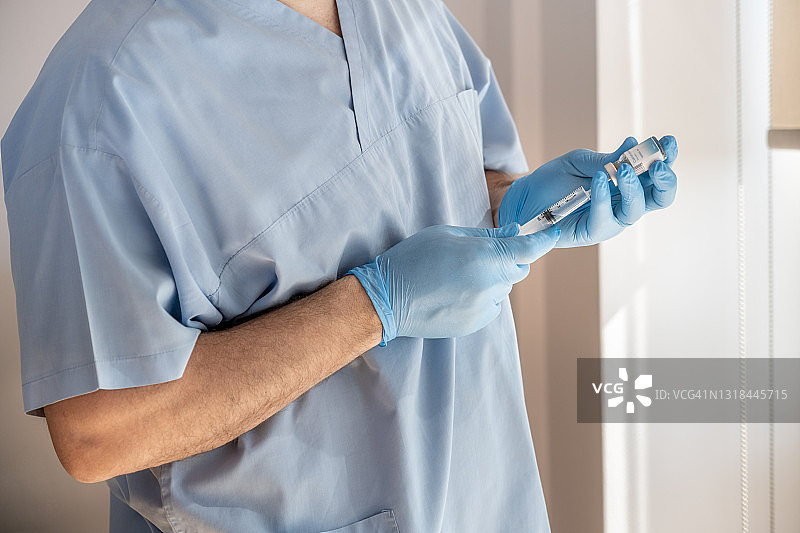 新冠病毒防护与疫苗：医生从疫苗瓶中抽取药液，为患者注射疫苗图片素材