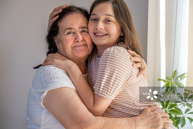 快乐的少女拥抱年迈的祖母图片素材