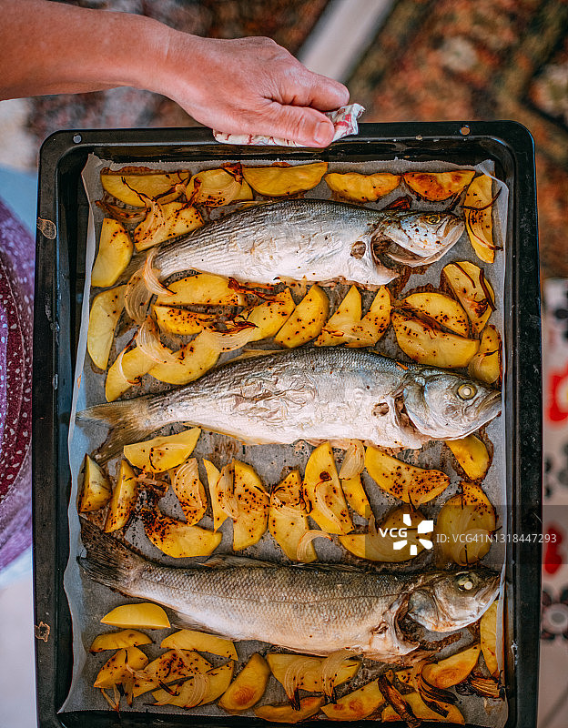 她端着烤鱼图片素材