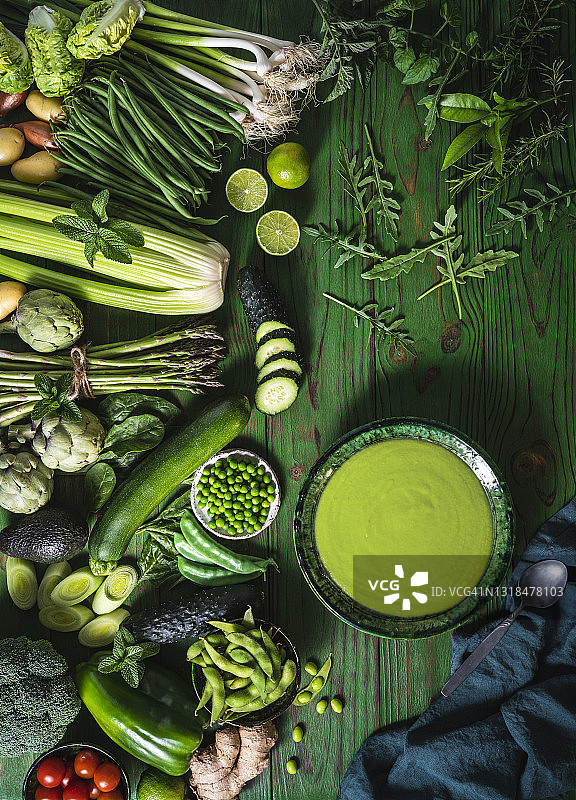 绿色木桌上的纯素生蔬菜配绿芦笋汤或豌豆汤图片素材