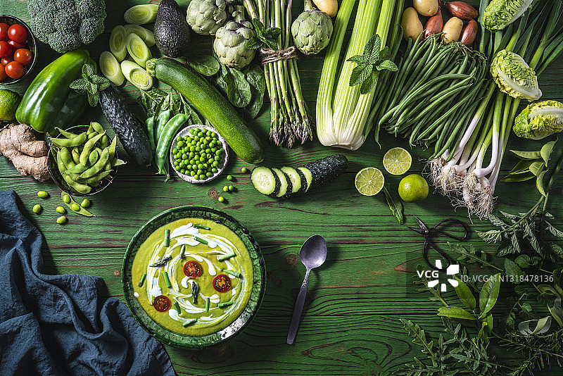 绿色木桌上的纯素生蔬菜配绿芦笋汤或豌豆汤图片素材