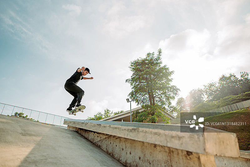 在滑板公园玩滑板的亚洲男人图片素材