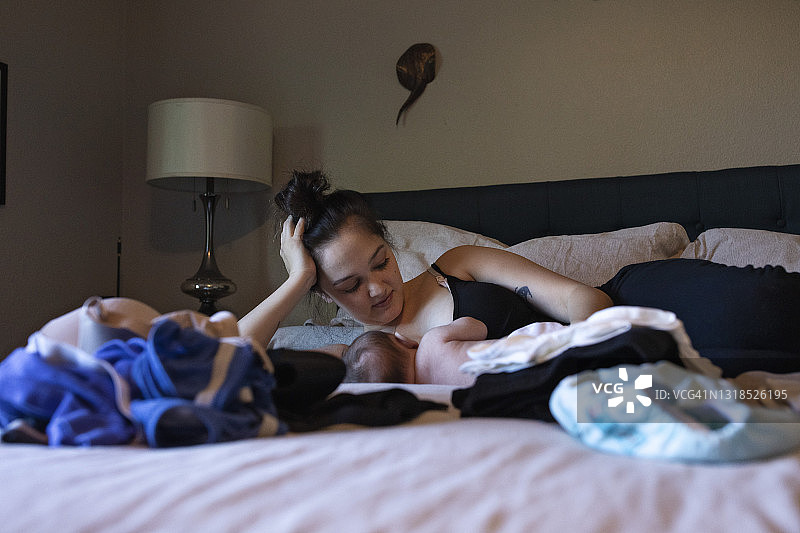 母亲躺下给婴儿喂母乳图片素材