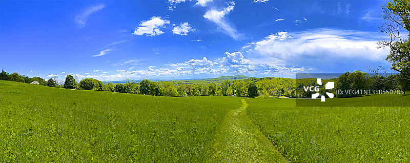 纽约州哈德逊奥拉纳，修剪过的草地、树木、山脉和云层形成的广角景观图片素材