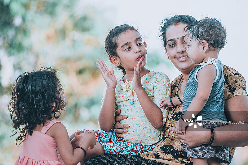 母亲在房子前和孩子们玩耍图片素材