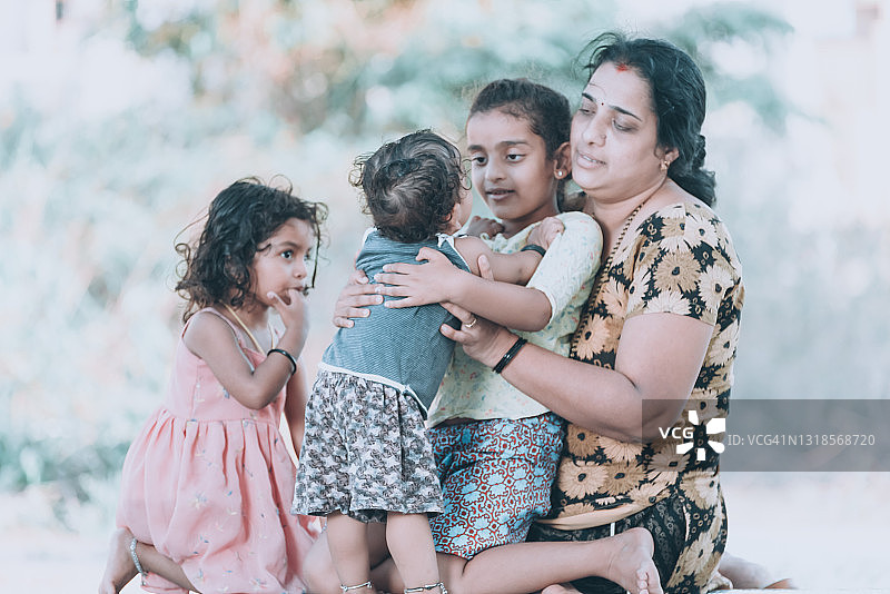 母亲在房子前和孩子们玩耍图片素材