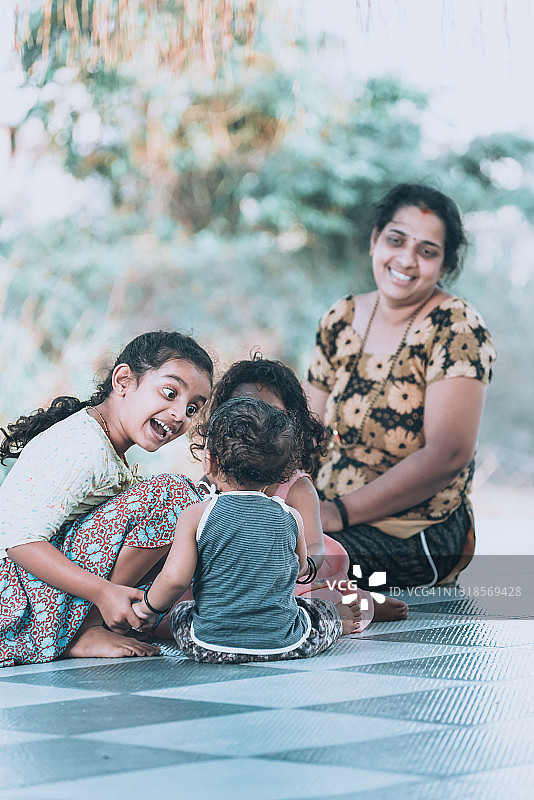 母亲在房子前和孩子们玩耍图片素材