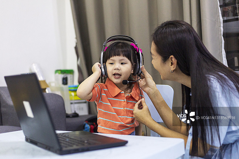 母亲和女儿在家中使用笔记本电脑图片素材