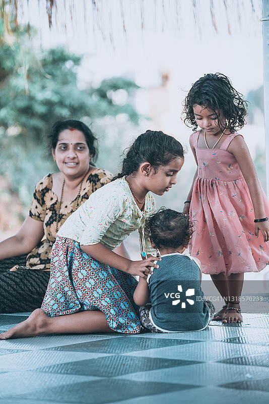 母亲在房子前和孩子们玩耍图片素材