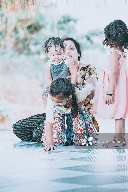 母亲在房子前和孩子们玩耍图片素材