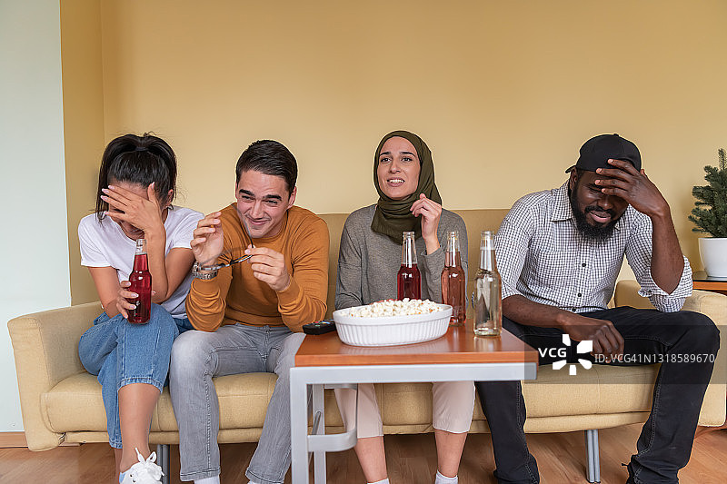 不同种族的快乐朋友们正在家看电视图片素材