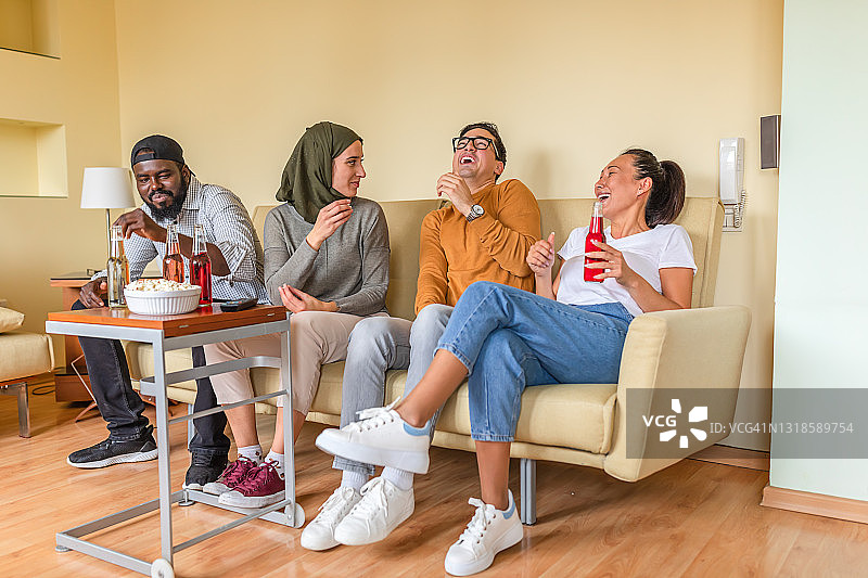 兴奋的多元文化年轻朋友在家看电影图片素材
