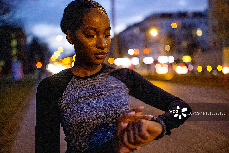 非洲裔女人查看智能手表上的锻炼进度图片素材