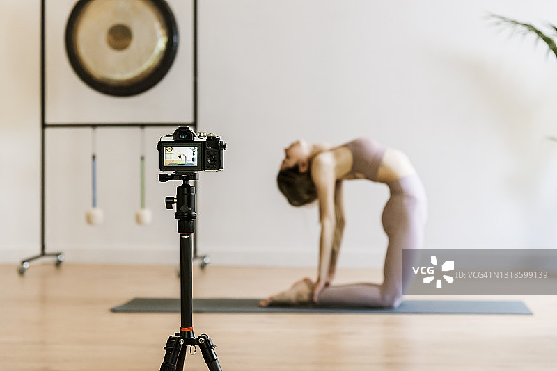 瑜伽教练在瑜伽中心用相机录制课程图片素材