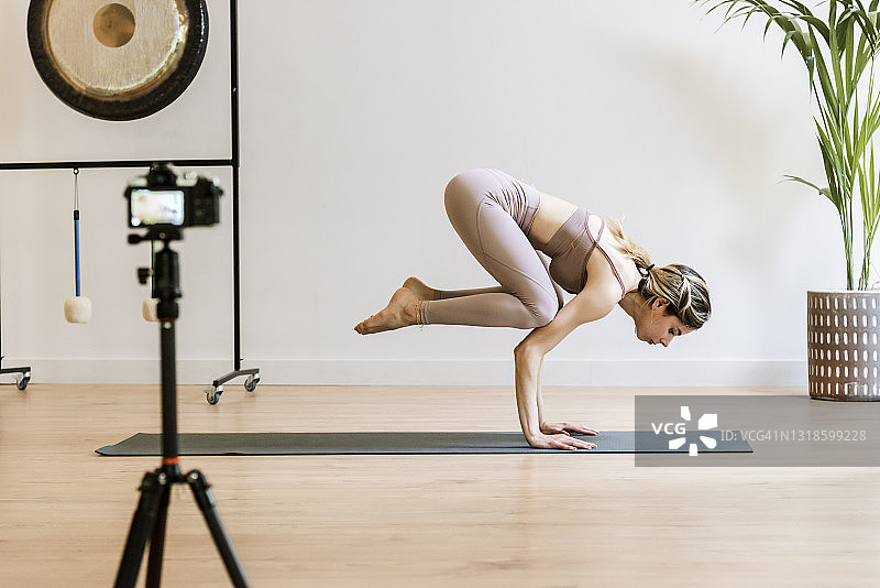瑜伽教练在瑜伽中心用相机录制课程图片素材