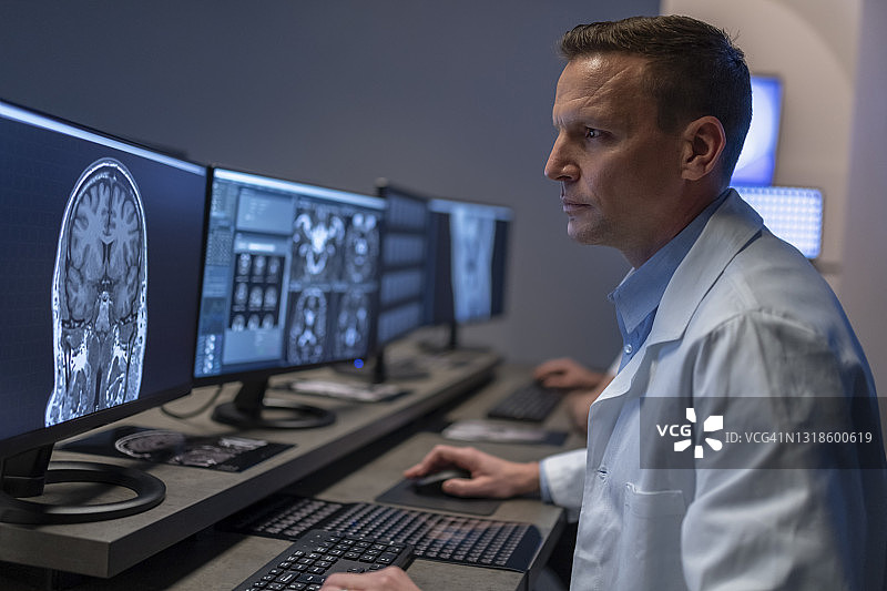 男放射科医生分析头部MRI图像图片素材