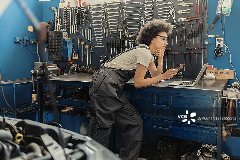 汽车维修服务中的女工使用科技产品图片素材