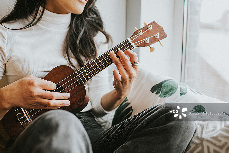 一名女子弹奏着尤克里里图片素材