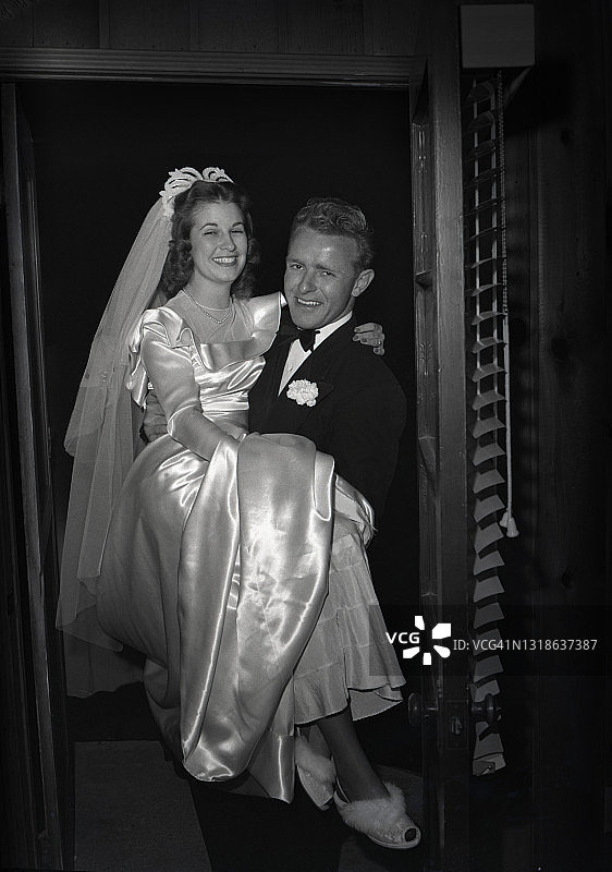 跨过门槛。1940年代的年轻夫妇黑白照图片素材