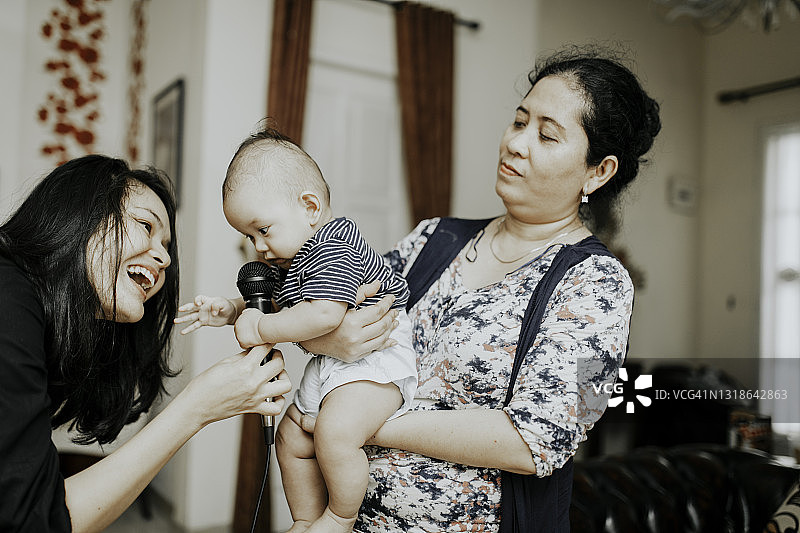 阿姨抱着坐在家里的侄女，开怀大笑图片素材