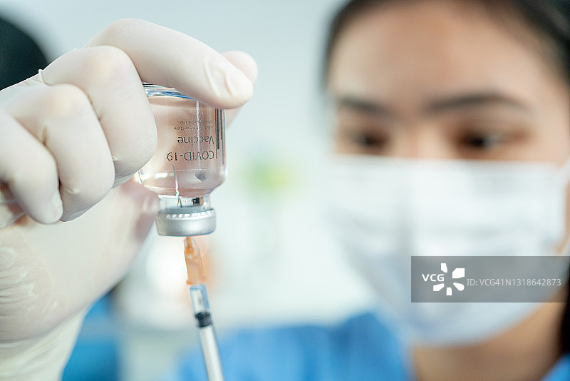 居家接种新冠疫苗，亚洲医生正在进行疫苗接种图片素材