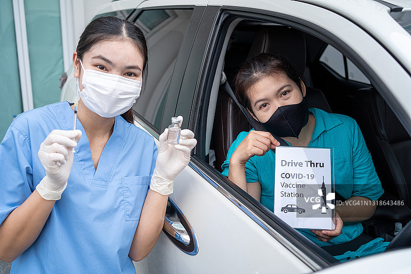 驾车接种疫苗点，亚洲年轻医生为驾车人士注射新冠疫苗图片素材