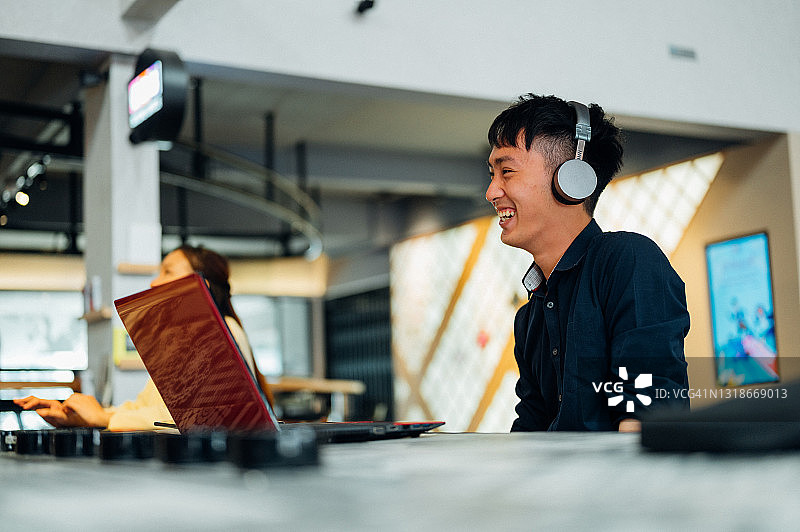 微笑的年轻亚洲男商人与客户伙伴进行视频通话图片素材