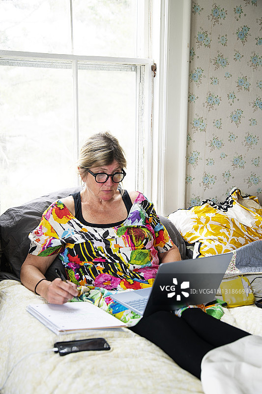 在床上工作场景：居家办公的女人图片素材