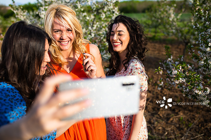 朋友在春天的果园里自拍图片素材