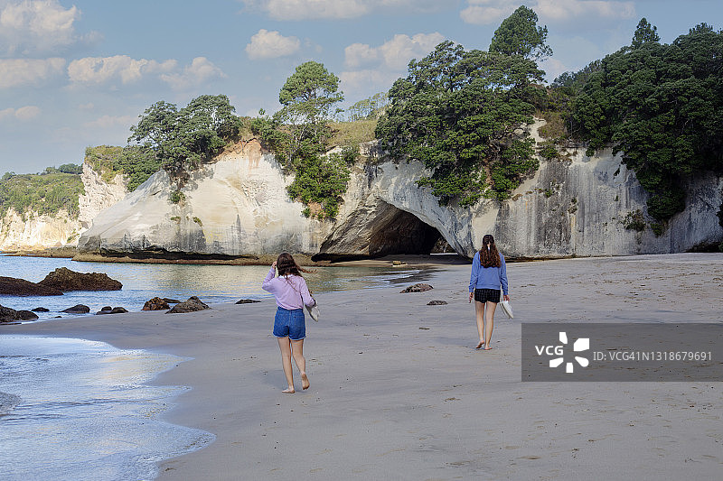 两名青少年沿着教堂湾海滩行走图片素材