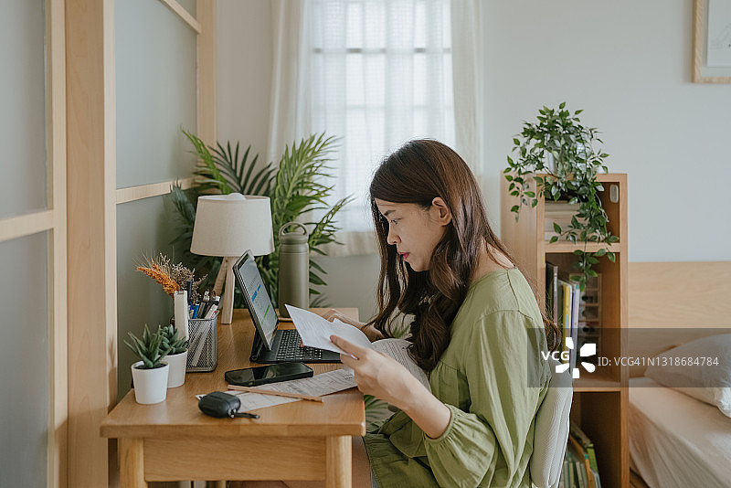 母亲在家使用笔记本电脑查看财务图片素材