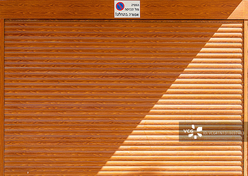 中午时分关闭的橙色卷帘门图片素材