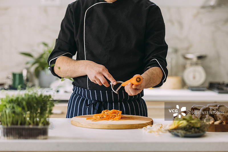 在私人厨房准备美味餐点的匿名白人专业男厨师图片素材