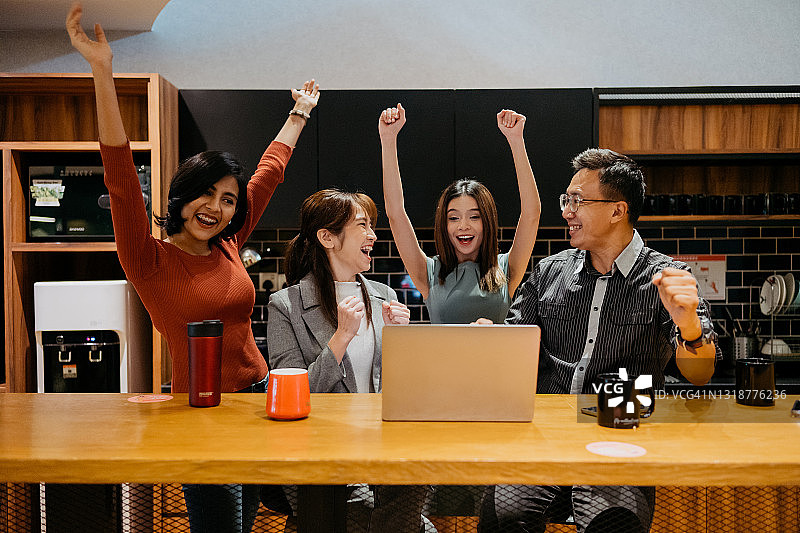 兴奋的亚洲办公室职员在办公室欢呼庆祝业务成功图片素材