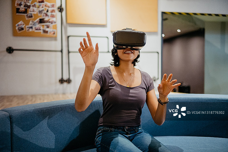 年轻女子戴VR眼镜玩虚拟现实游戏图片素材