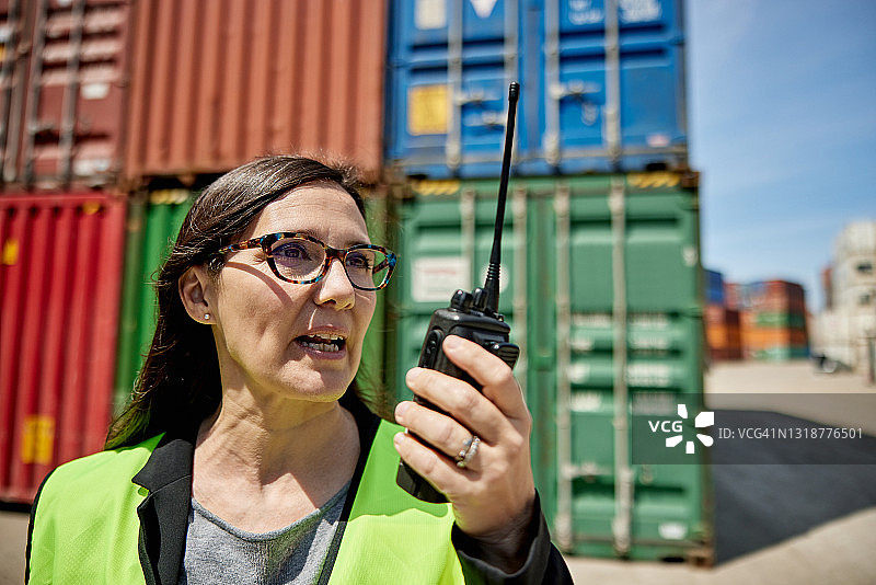 使用对讲机的西班牙裔女性物流主管图片素材