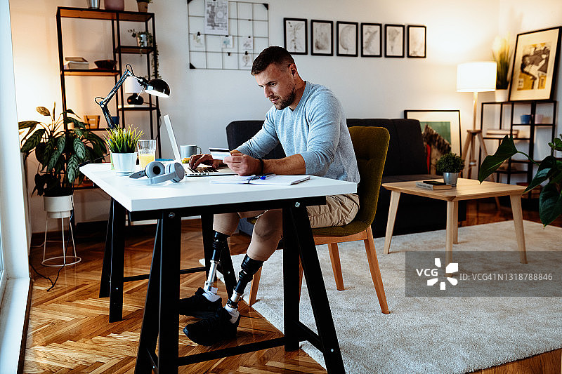 截肢男子在家用信用卡进行网上购物图片素材