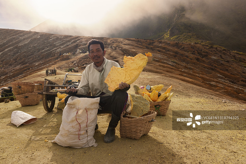 手提天然硫磺的印度尼西亚矿工图片素材