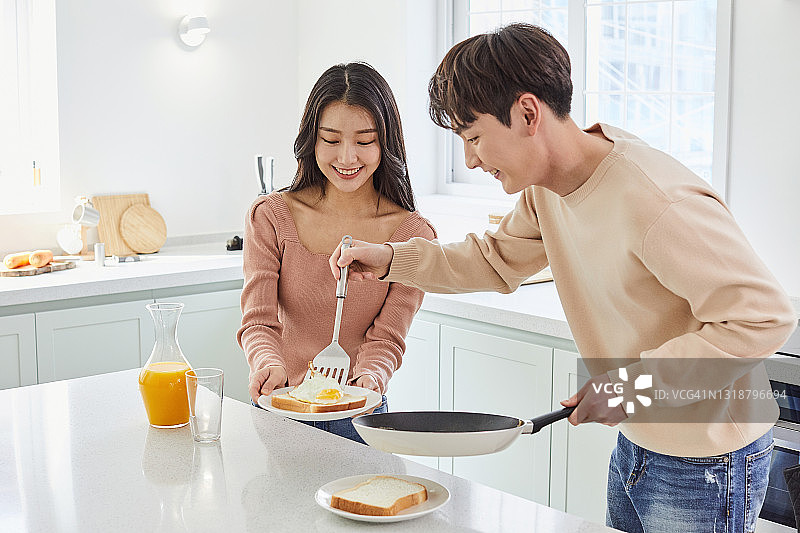 一对情侣在厨房准备早餐图片素材