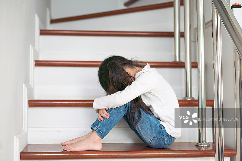 双手抱头坐在楼梯上的问题儿童图片素材