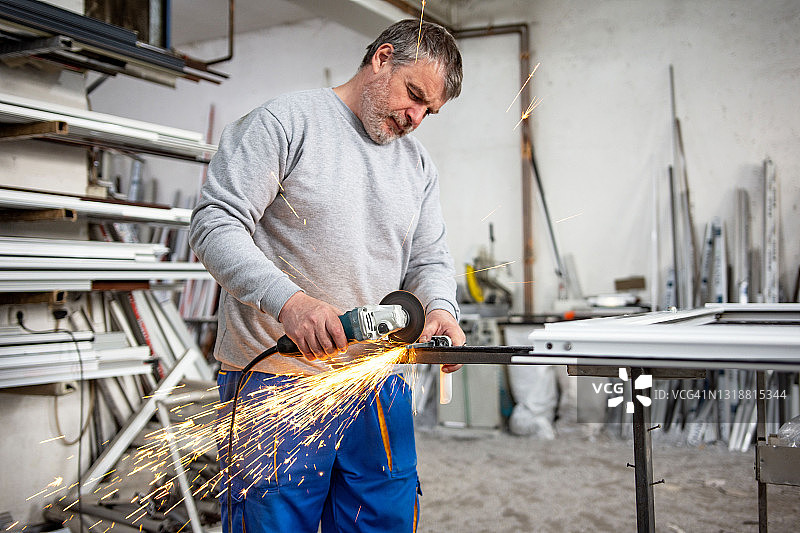 用角磨机在车间切割金属，特写图片素材