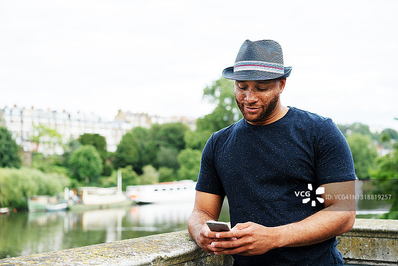 戴帽子的男人使用智能手机图片素材