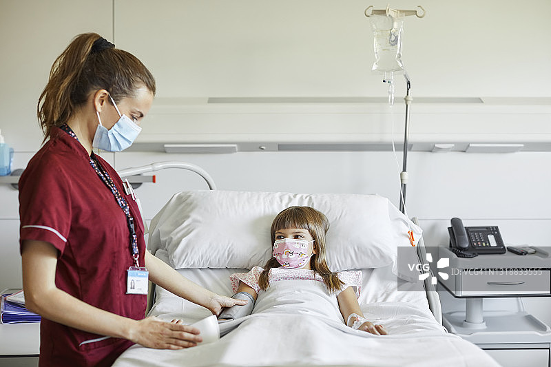 女护士在医院为女孩测脉搏图片素材