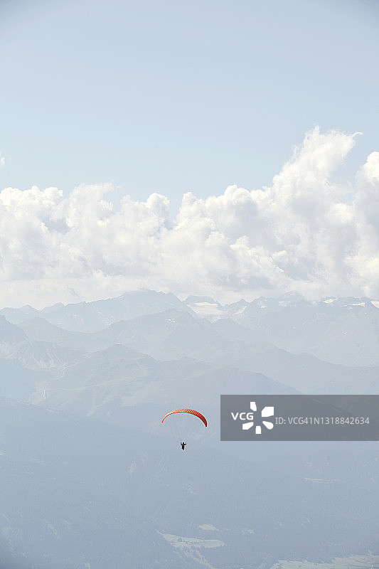 天空中孤立的滑翔伞与远处的山脉图片素材