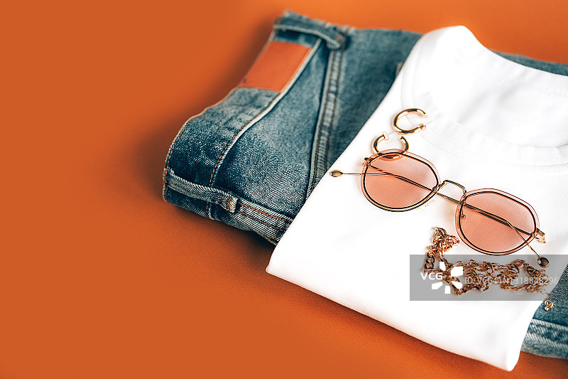 时尚女性夏季基础穿搭：太阳镜、牛仔短裤、白色T恤和配饰平铺图图片素材